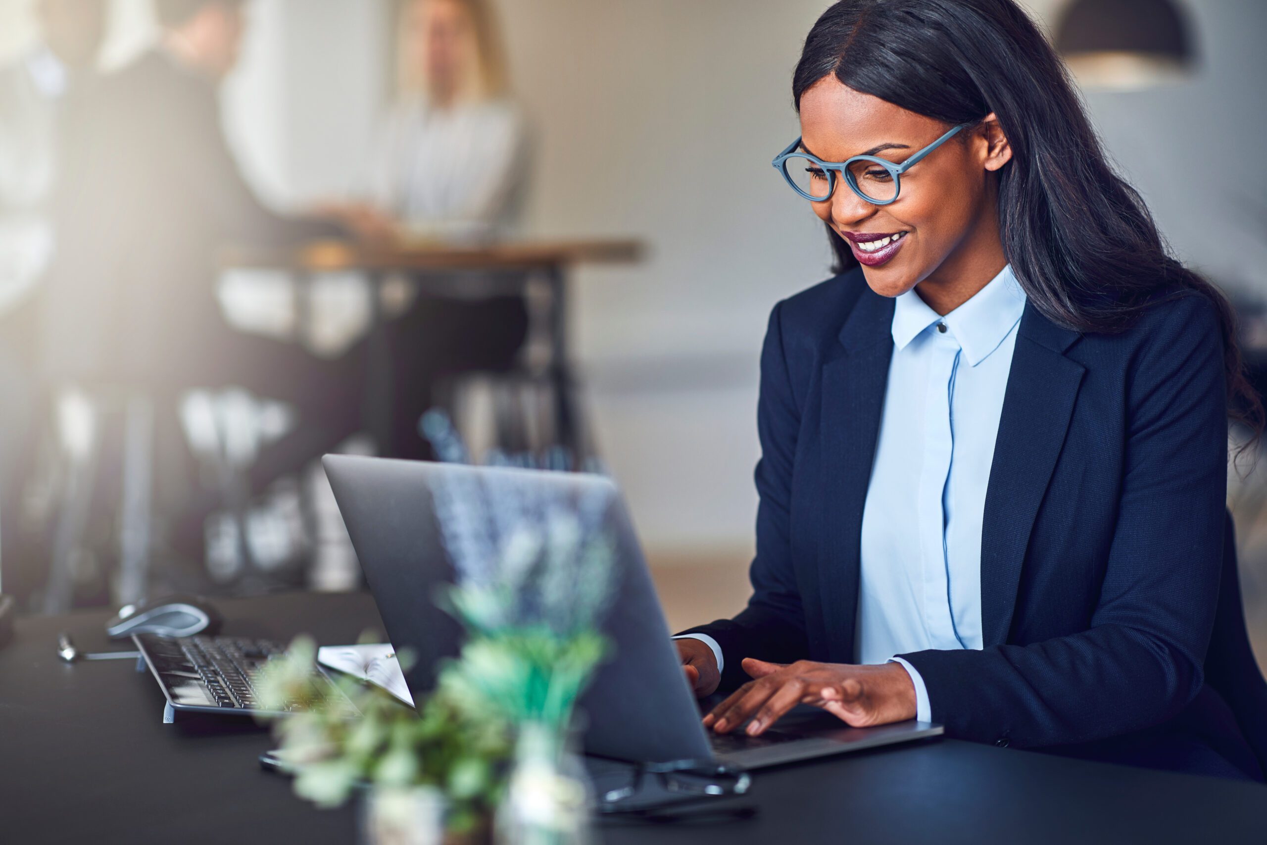 Smiling,Young,African,American,Businesswoman,Working,On,A,Laptop,At