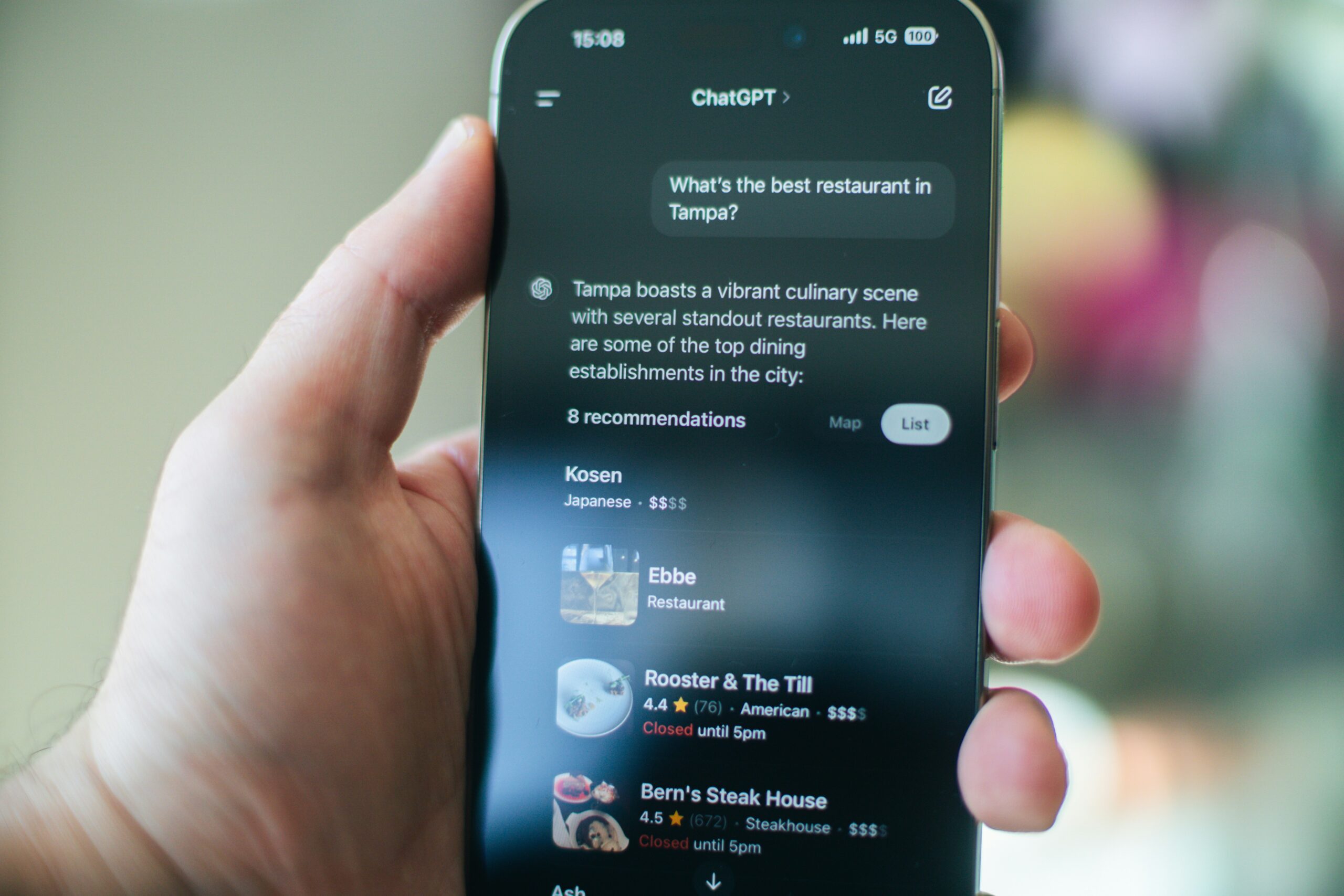 aerps-com-t64QNuifdN8-unsplash A mobile in a hand with a question for ChatGPT. ChatGPT has responded with an answer and suggestions. SEO, AEO, GEO